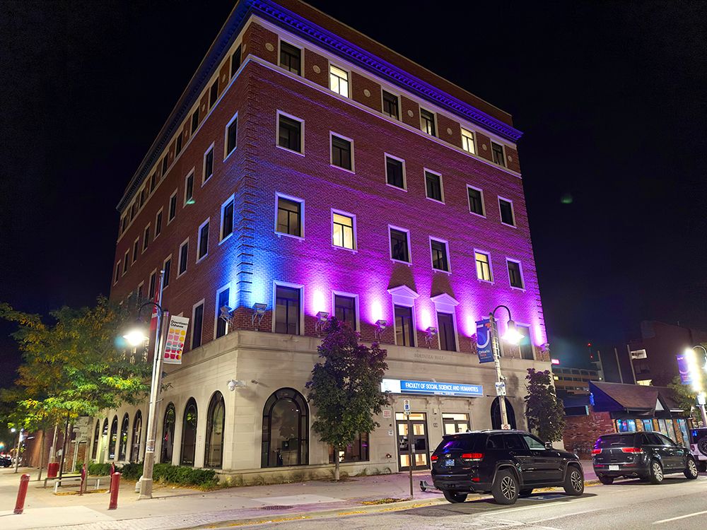 Bordessa Building lit up at night in purple and blue in support of DEAM